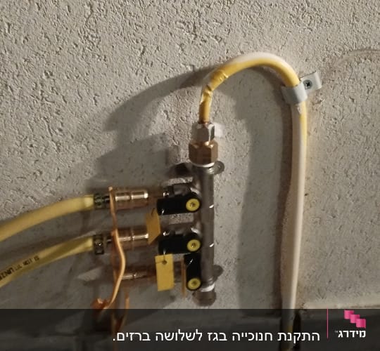 צינורות גז מחוברים לשסתום על קיר בטון